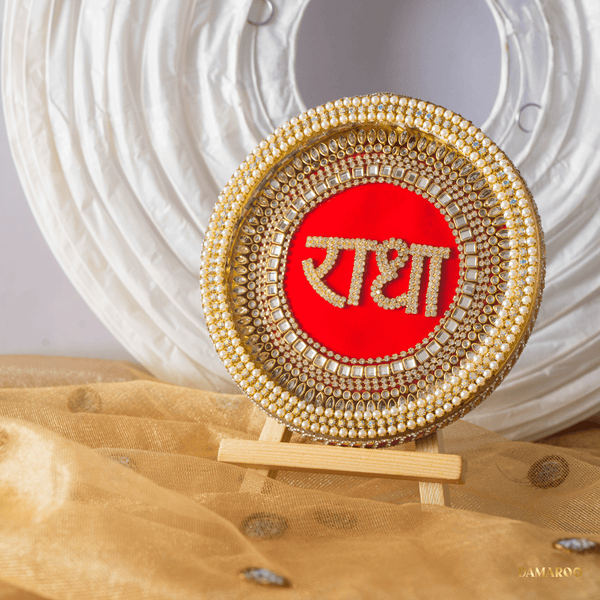 Glowing LED Radha Naam Frame in Hindi on red velvet. Handcrafted 5-inch circular frame with stone work illuminated in the dark for meditation focus. Includes wooden stand.